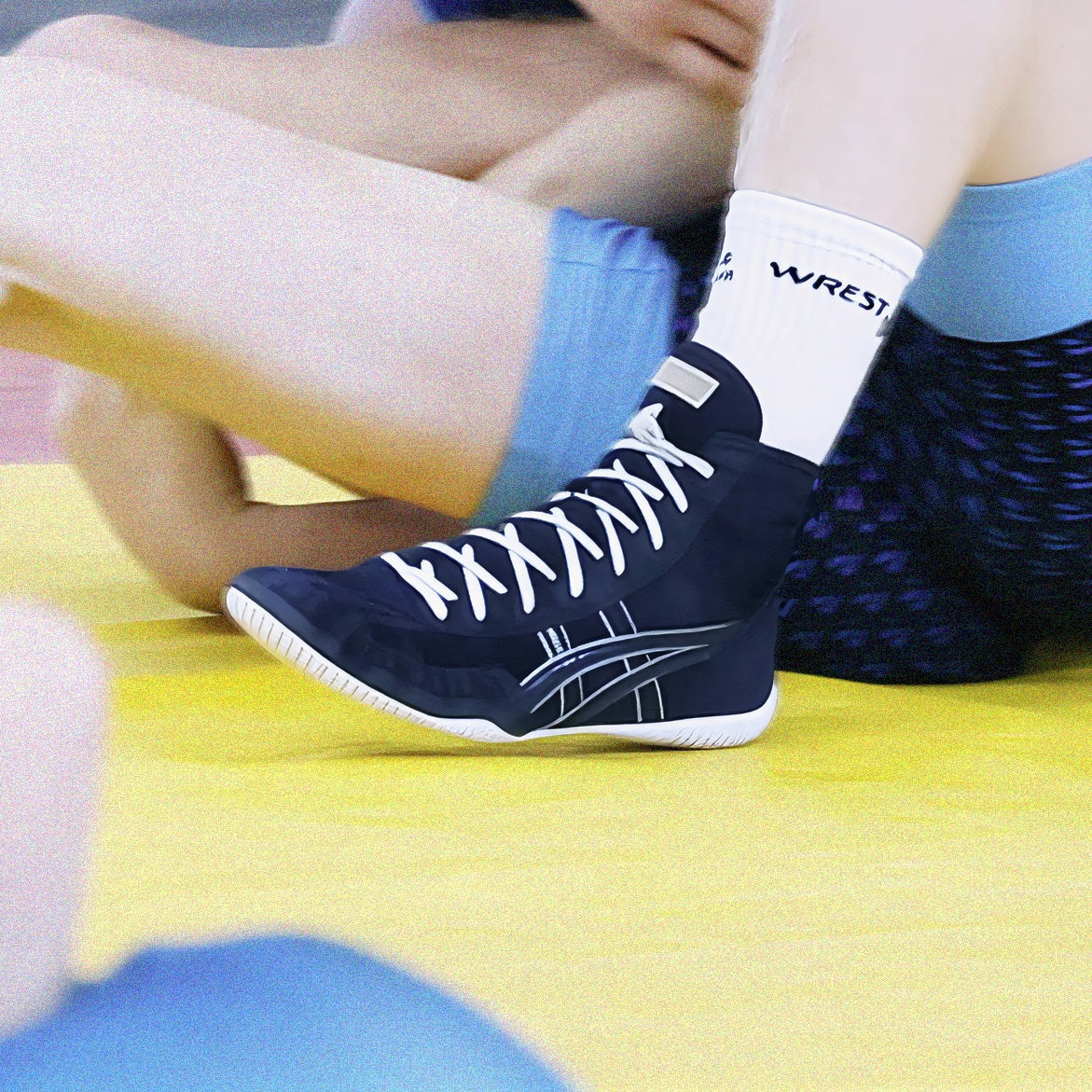 Ringerschuh beim Training auf der Matte mit hoher Schnürung in schwarz, getragen mit weißen WrestlerStore Socken