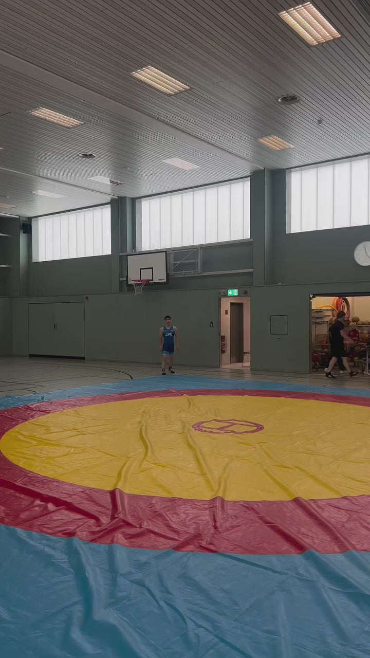 Ringer führt Techniktraining im elastischen Ringertrikot von WrestlerStore aus.